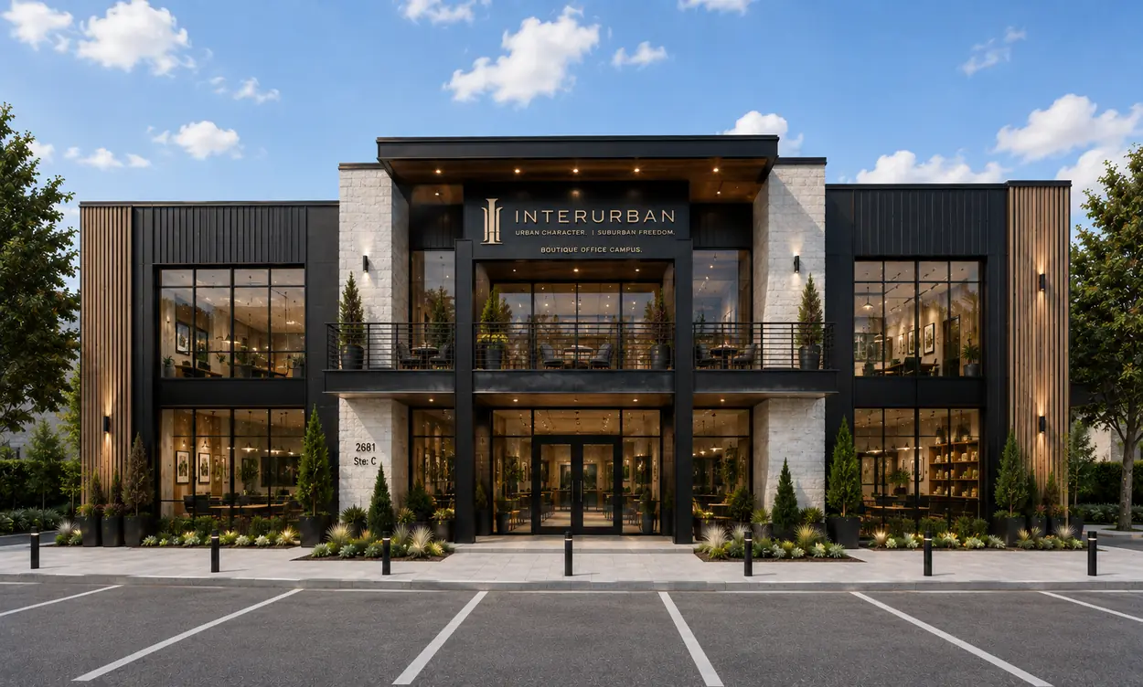 Front elevation of a two-story office building in white stone and blackened steel with a double-height glass entry and balcony